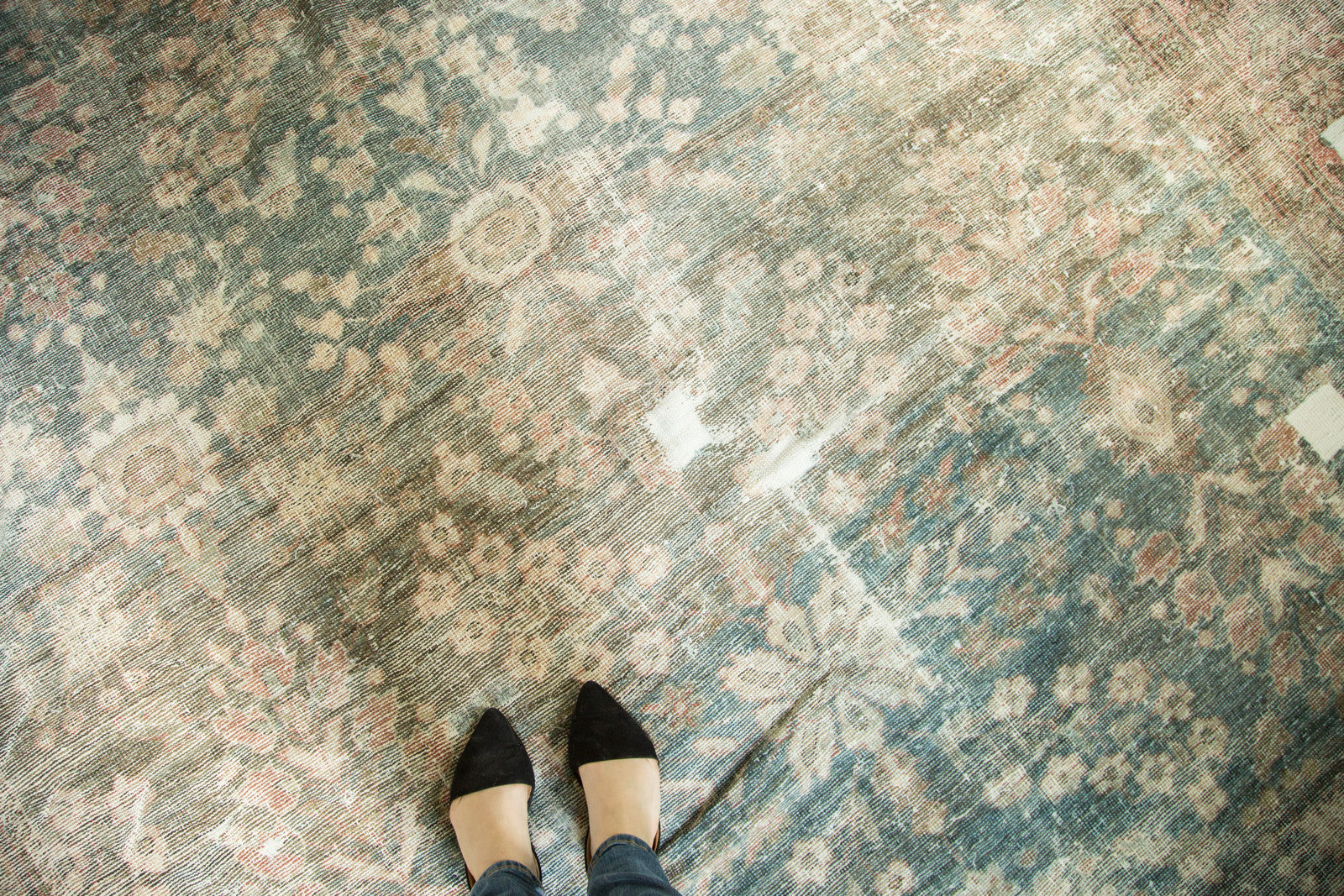 Distressed Persian Mahal rug showing worn floral field in dusty teal and faded red.